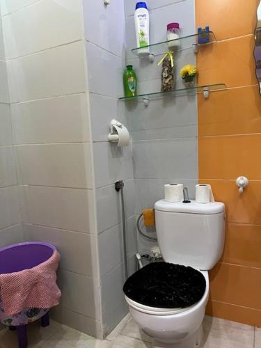 a bathroom with a white toilet with a black seat at Résidences tazerzit smouna in Agadir