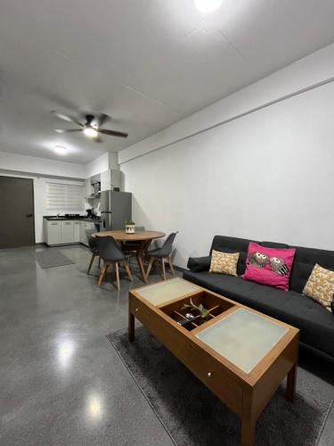 a living room with a black couch and a table at New furnished apartment near BBVA Stadium in Monterrey