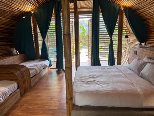 a bedroom with a bed with blue drapes at Kenanga Bamboo Villa in Dinalupihan