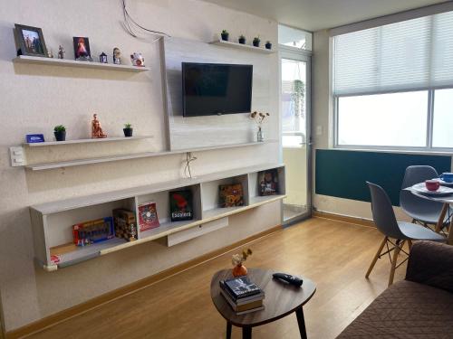 een woonkamer met witte planken en een tv bij Departamento moderno con buena ubicación in Lima