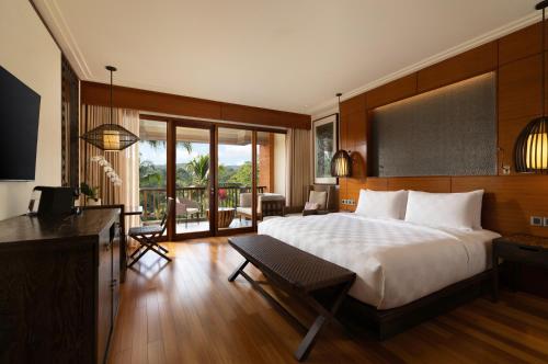a hotel room with a bed and a balcony at Padma Resort Ubud in Payangan
