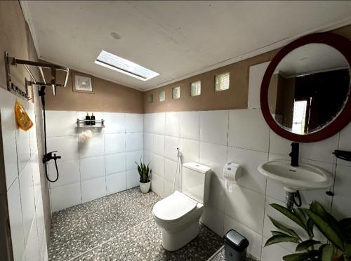 a bathroom with a toilet and a sink and a mirror at Tetebatu flower in Tetebatu