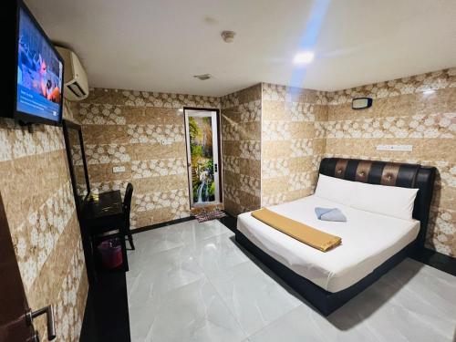 a bedroom with a bed and a flat screen tv at Silver Sky hotel in Kuala Lumpur