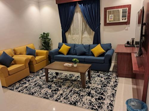 a living room with two couches and a coffee table at أجنحة المدينة للشقق المفروشة in Al Madinah
