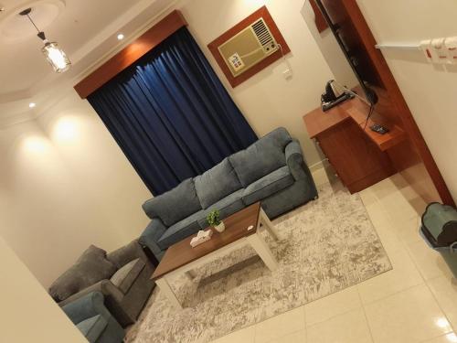a living room with a couch and a table at أجنحة المدينة للشقق المفروشة in Al Madinah