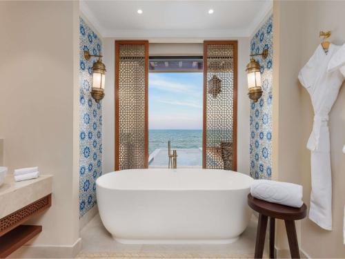 a bathroom with a tub and a view of the ocean at Sofitel Bahrain Zallaq Thalassa Sea & Spa in Manama