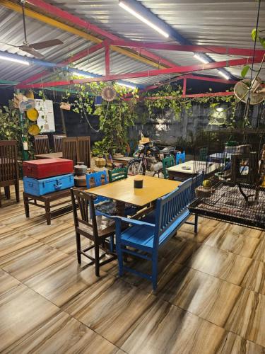a table and chairs in a room with plants at Dream Vision Guest House in Diu