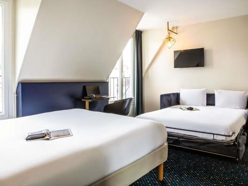 a hotel room with two beds and a tv at ibis Styles Paris 15 Lecourbe in Paris