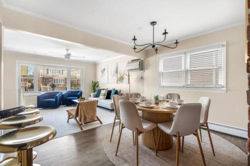 a dining room and living room with a table and chairs at Modern 3BR Near EWR, Parking, 25 Min NYC in Kearny