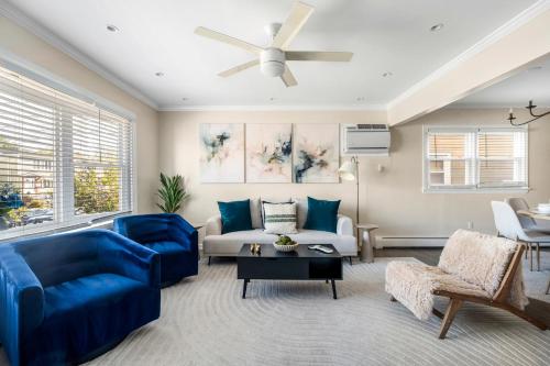 a living room with blue furniture and a ceiling fan at Modern 3BR Near EWR, Parking, 25 Min NYC in Kearny