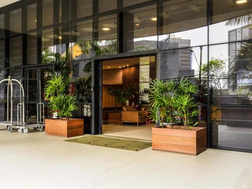 Un edificio con plantas en macetas en frente de él. en Mercure Salvador Boulevard Hotel, en Salvador