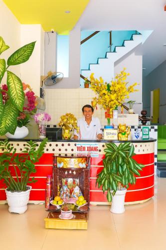 a chef standing behind a counter with plants at Nam Dương 1 Hotel in Phan Rang–Tháp Chàm