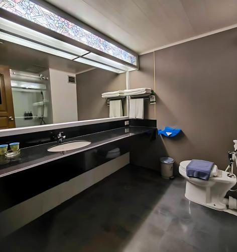 a bathroom with a sink and a toilet and a mirror at Pattaya Park Beach Resort in Pattaya South