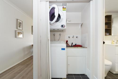 a white laundry room with a washer and dryer at Quiet Retreat Close to City Centre and Lake - Hosted by Canstay in Canberra