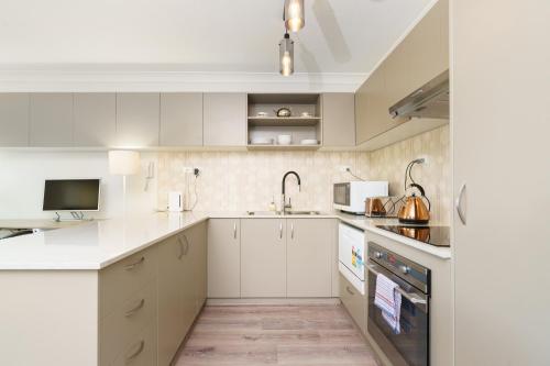 a kitchen with white cabinets and a sink at Quiet Retreat Close to City Centre and Lake - Hosted by Canstay in Canberra