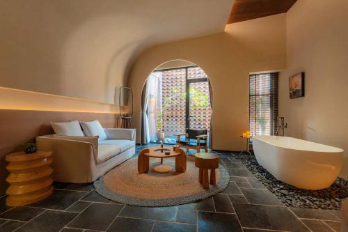 a living room with a couch and a bath tub at The Woven Inn in Shunde