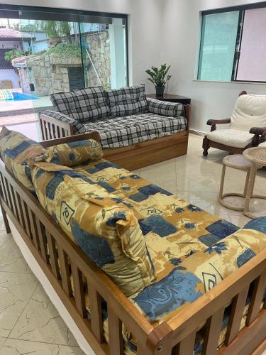 a large bed in a living room with a couch at casa completa enseada guaruja in Guarujá