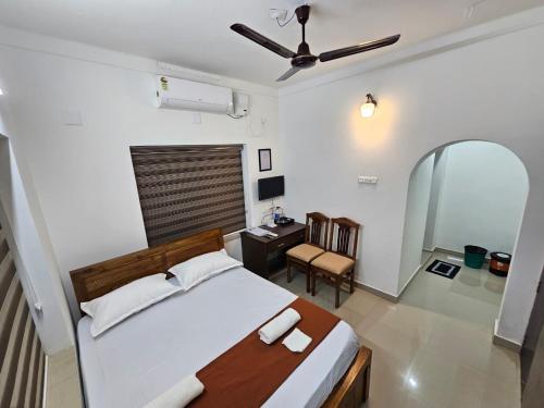 a bedroom with a bed and a desk in it at Guruvayur Nest Homestay in Guruvāyūr