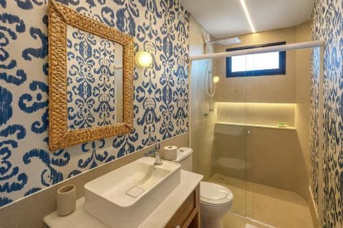 a bathroom with a sink and a toilet and a mirror at Apartamento no Falésias de Pipa - Veleiros 212 in Pipa