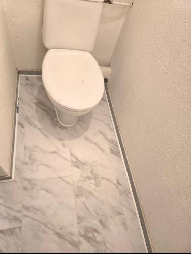 une salle de bain avec des toilettes blanches dans une chambre dans l'établissement Le Stud, à Belfort
