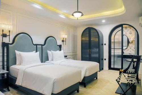 にあるSwiss-Belexpress Paluのベッド2台と椅子が置かれた寝室