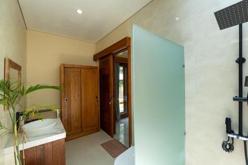 y baño con armario de madera y lavabo. en Sinden Villa, en Payangan
