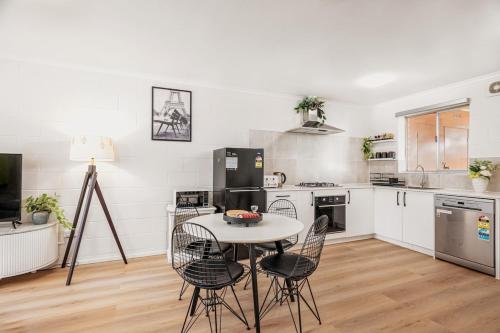 a kitchen with a table and chairs in it at Sunny Stay Near Flinders & CBD