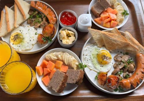 a wooden table topped with plates of breakfast foods at The Garden Grove Villa in Yatiyana