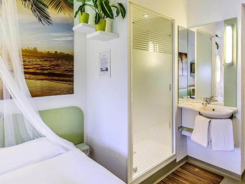 a small bathroom with a sink and a shower at ibis budget Berlin Kurfürstendamm - neu renoviert in Berlin