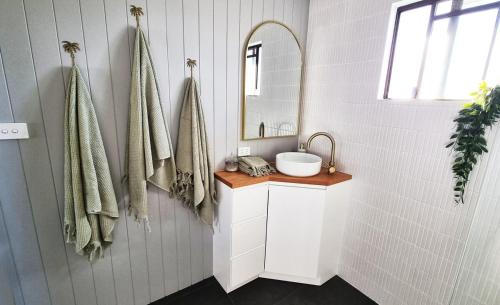 a bathroom with a sink and a mirror at Wurtulla Guesthouse, Modern & Tranquil in Kawana Waters