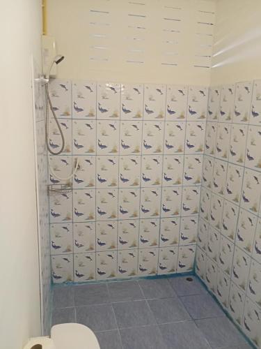 a bathroom with a toilet and a white tiled wall at Lakchai Resort in Ko Chang