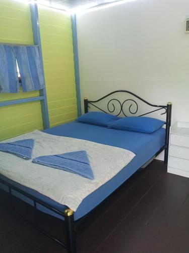 a bedroom with a bed with blue sheets and blue pillows at Lakchai Resort in Ko Chang