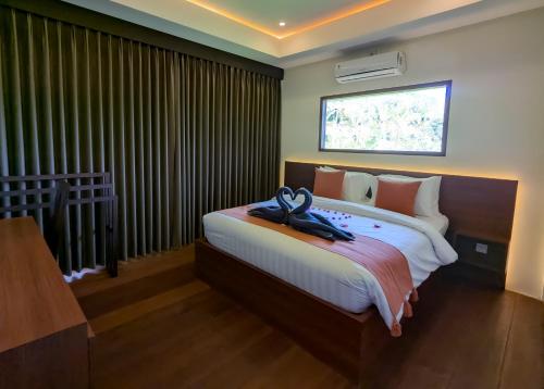 a bedroom with a large bed with a large window at Semu Villas kerujuk in Pawenang