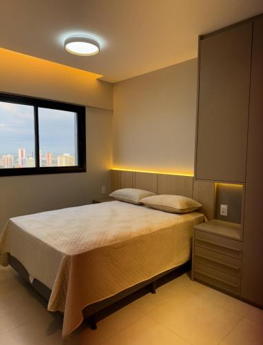 a bedroom with a large bed and a window at Apto 31º andar, 4km do centro, colado ao Umarizal in Belém