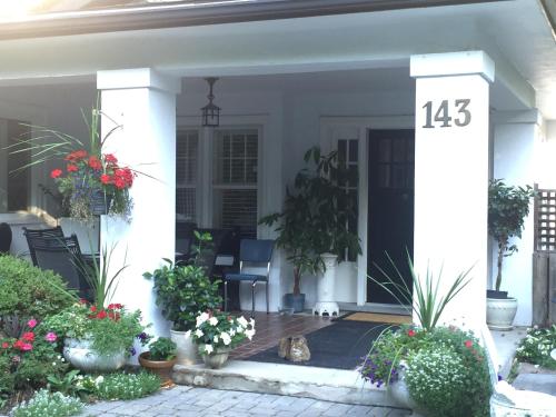 a front porch with potted plants and a number at Bernard Gray Hall Bed and Breakfast in Niagara-on-the-Lake