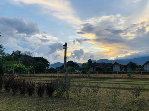 a field with a fence and a pole in the grass at Sparrow Hut in Pai