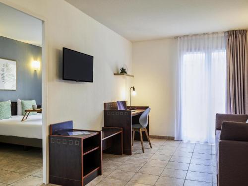 a hotel room with a desk and a bed at Aparthotel Adagio Access Nice Garibaldi in Nice
