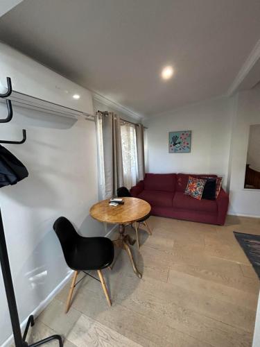 King River Caravan Park في Whitfield: غرفة معيشة مع طاولة وأريكة حمراء