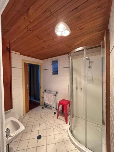 King River Caravan Park في Whitfield: حمام مع دش ومقعد احمر