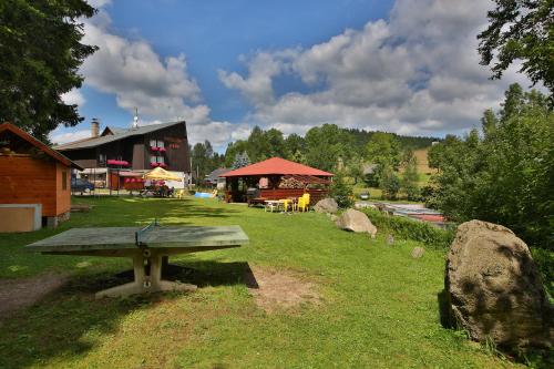 un tavolo da picnic in un parco con un edificio di Penzion HANA a Albrechtice v Jizerských horách