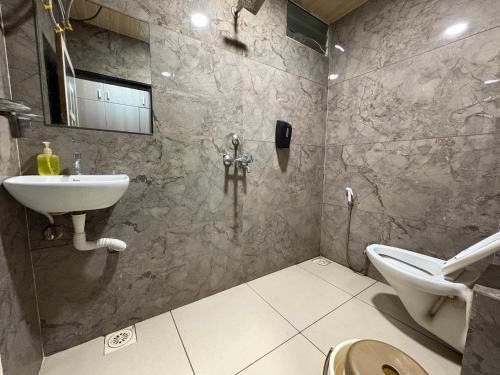un baño con lavabo e inodoro en Hotel Anantshree, en Ujjain