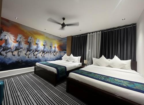 a hotel room with two beds and a painting of horses at Silk White in Hyderabad