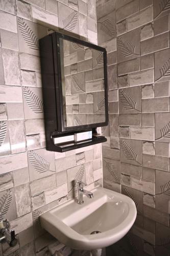 a bathroom with a sink and a mirror at Stanza Premium Hotels in Bhubaneshwar