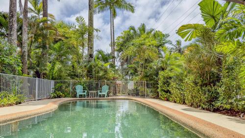 米申海滩Liana 10 One bedroom beachfront views的一个带两把椅子的游泳池,棕榈树