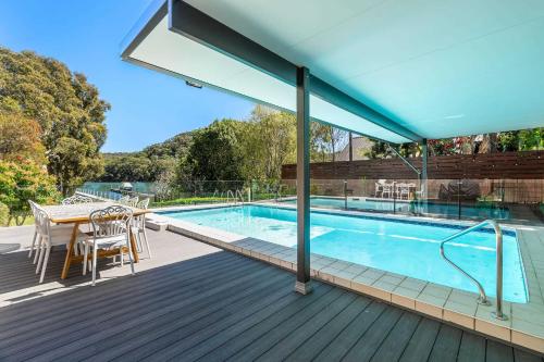 a swimming pool on a deck with a table and chairs at Casa Di Angelina By Coast Hosting in Blackwall