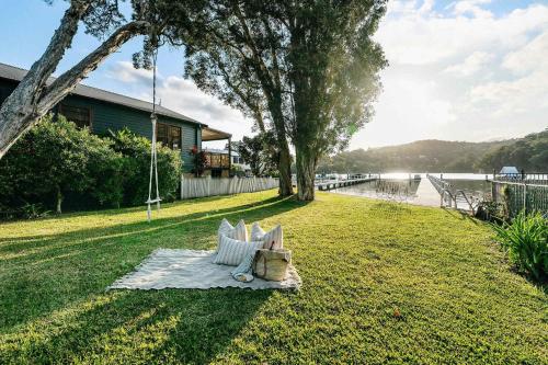 a bench sitting on the grass next to a lake at Casa Di Angelina By Coast Hosting in Blackwall