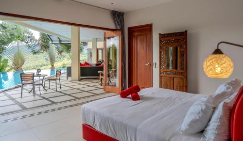 a bedroom with a bed with a red teddy bear on it at The Diamond Villa - Private Pool, Jacuzzi & Views in Pantai Cenang