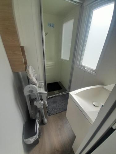Un baño con ducha, lavabo y espejo. en Mh 3 ch - 1 sdb - terrasse couverte - kerlann, en Pont-Aven