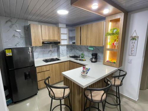 een keuken met een koelkast en een tafel met stoelen bij Comfortable Mini apartment cerca de Chipichape in Estación El Salto