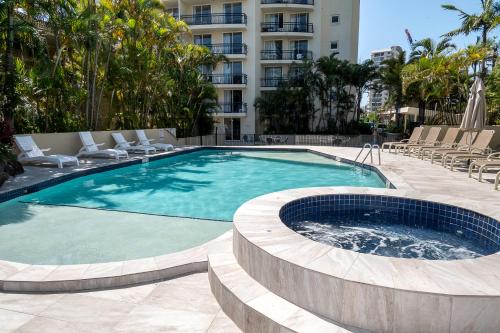 a large swimming pool with chairs and a building at Palazzo Colonnades in Gold Coast
